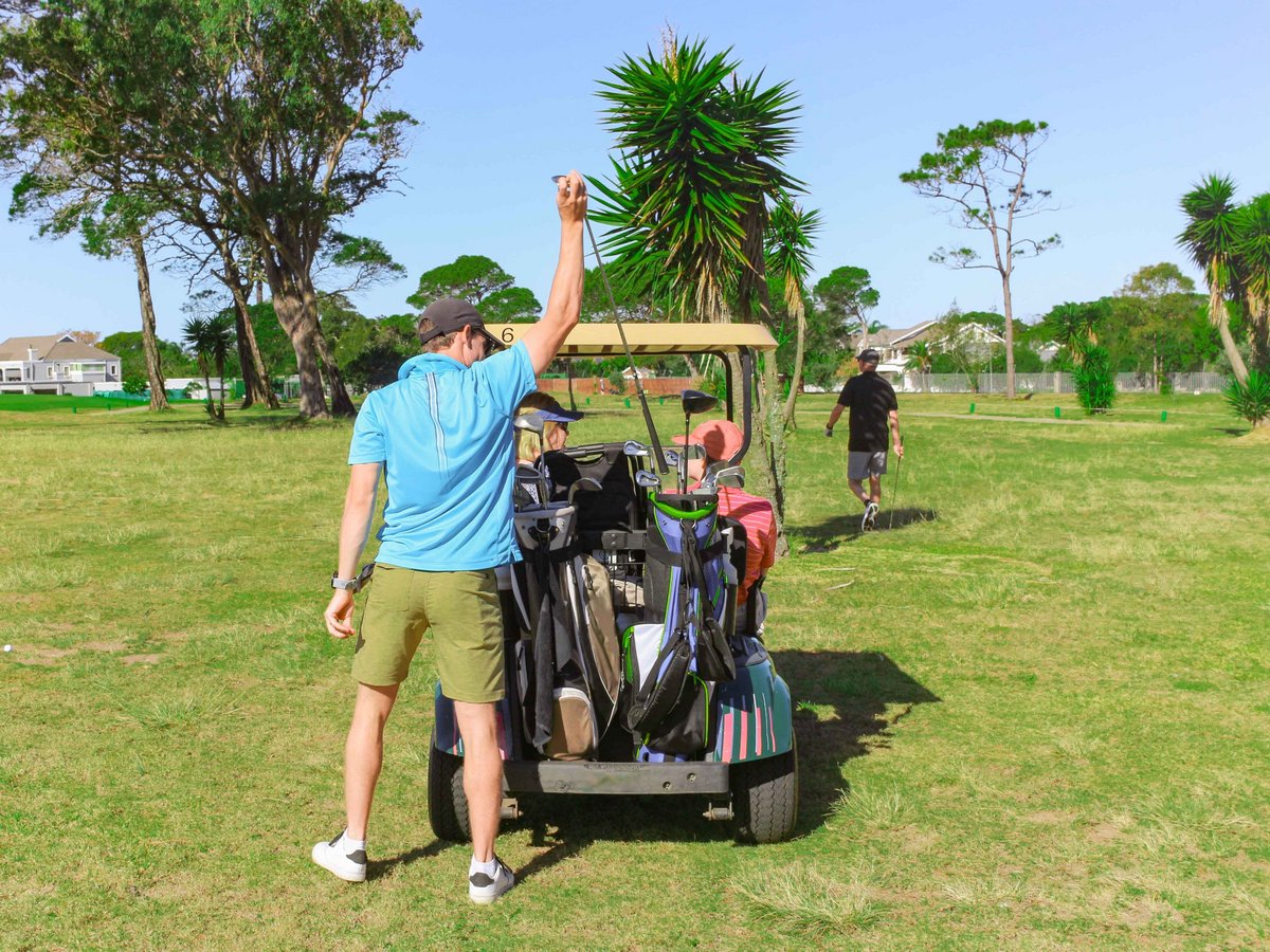 Golfer steckt Golfschläger in die Caddytasche