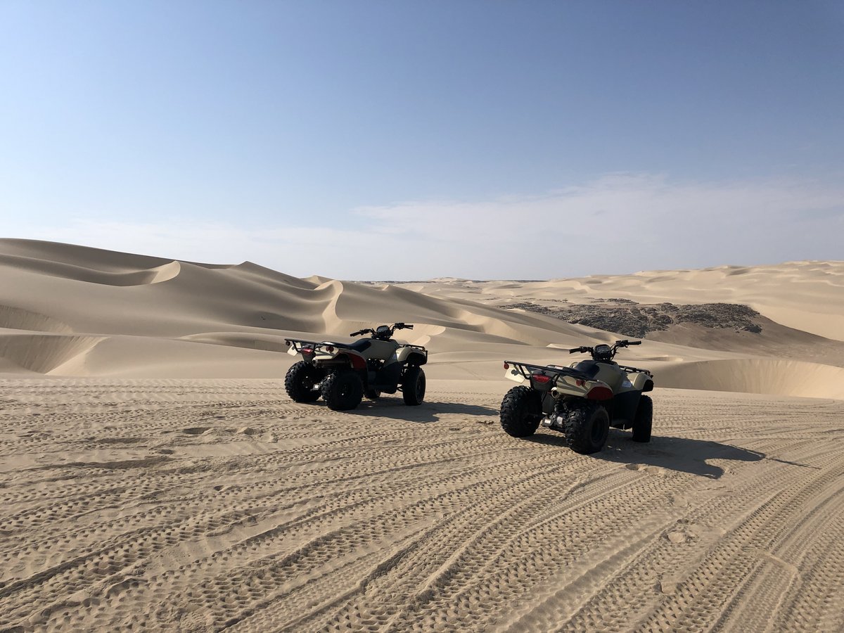 Zwei Quads in weiter Dünenlandschaft.